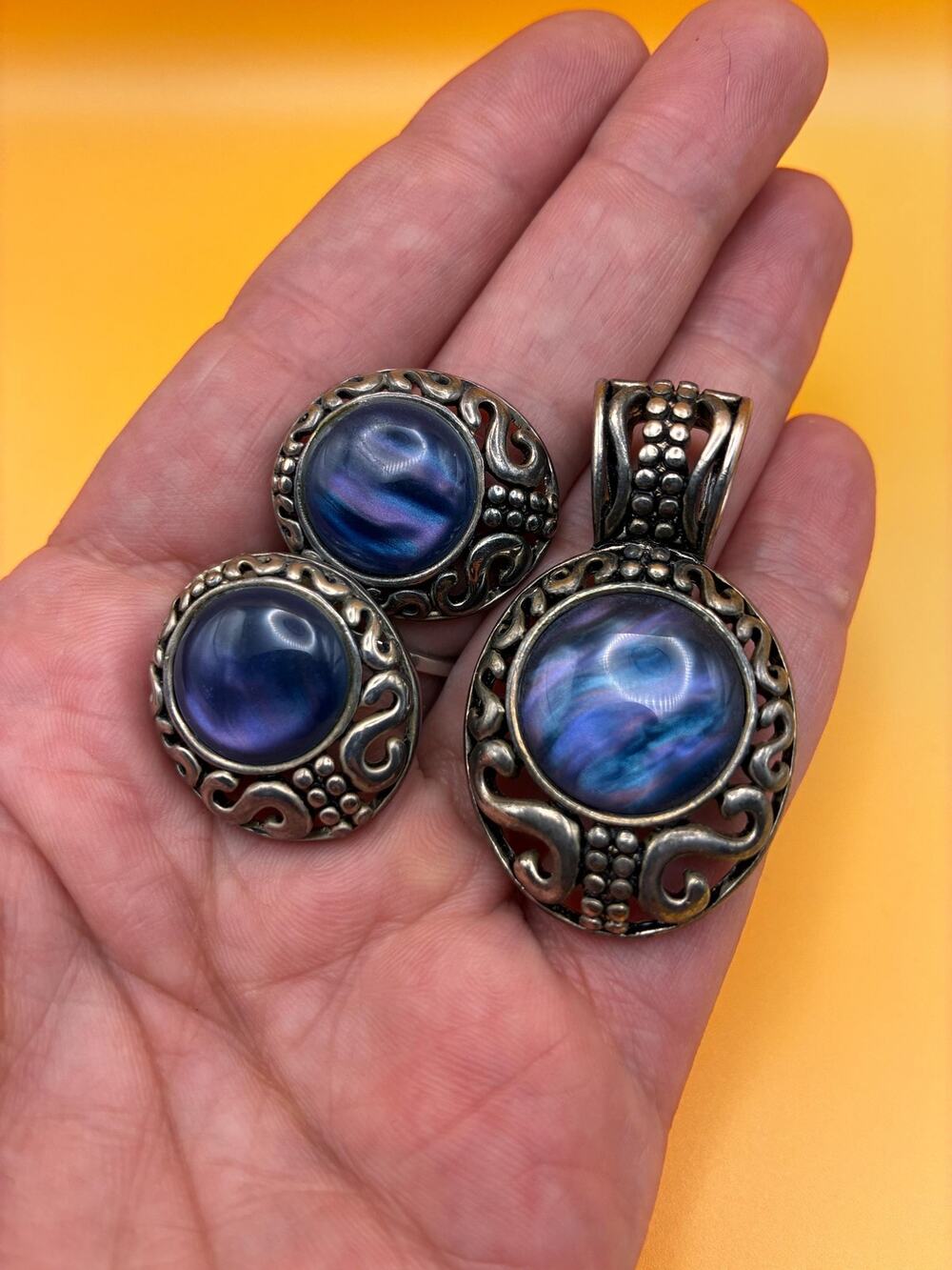 Sliver oval filagree stud earrings. Irridesant purple/blue center stone.